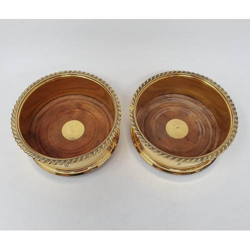 664 - A pair of George III style silver gilt wine coasters, initialled, London 1985, 11 cm diameter (2)