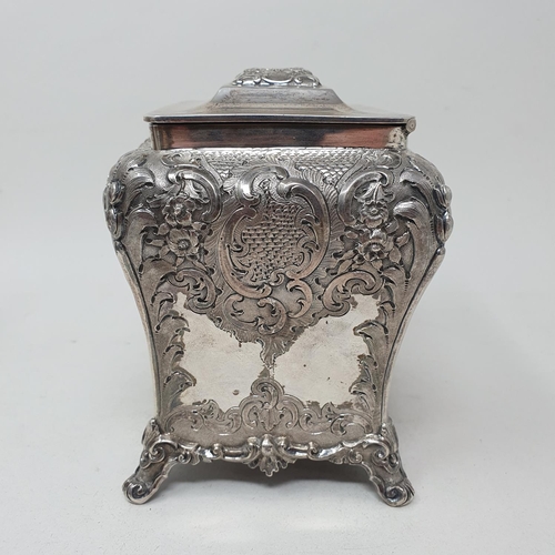 579 - A mid 19th century Scottish silver tea caddy, engraved an armorial, and embossed with flowers and fo... 