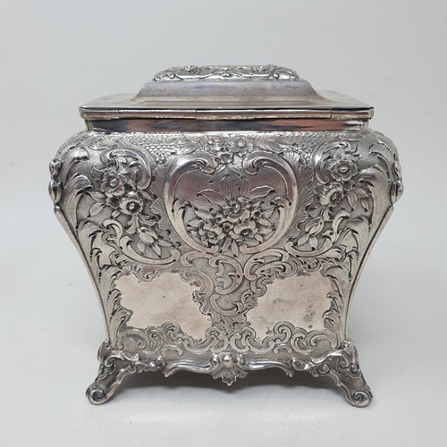 579 - A mid 19th century Scottish silver tea caddy, engraved an armorial, and embossed with flowers and fo... 