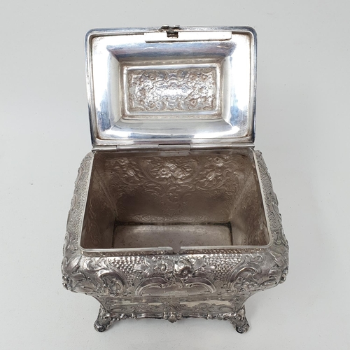 579 - A mid 19th century Scottish silver tea caddy, engraved an armorial, and embossed with flowers and fo... 