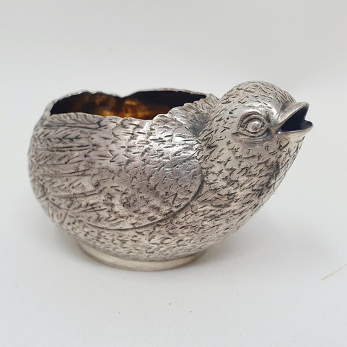 674 - A novelty silver coloured metal sauce boat, in the form of a chick, 5cm high