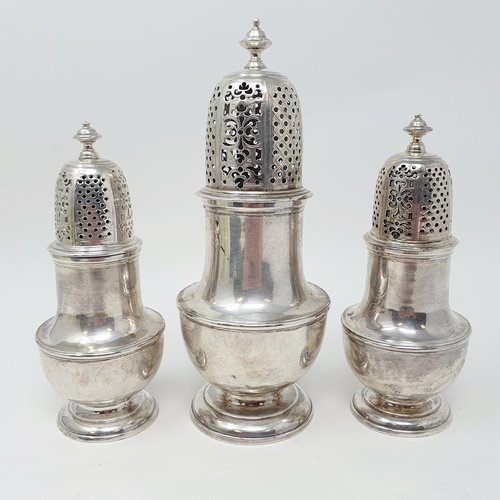 679 - A set of three George II silver casters, with pierced tops, the bodies of vase form, London 1731, 20... 