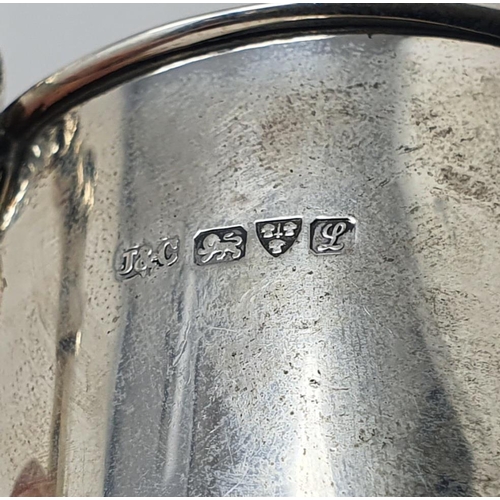 663 - A silver christening mug, decorated cherub face masks, chester 1911, 2.7 ozt, 10.5 cm high