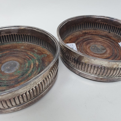 577 - A pair of early 19th century silver wine coasters, with reeded lower bodies, marks indistinct (2)