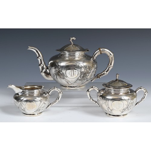 645 - A Chinese silver coloured metal three piece tea set, monogramed and decorated bamboo, comprising a t... 