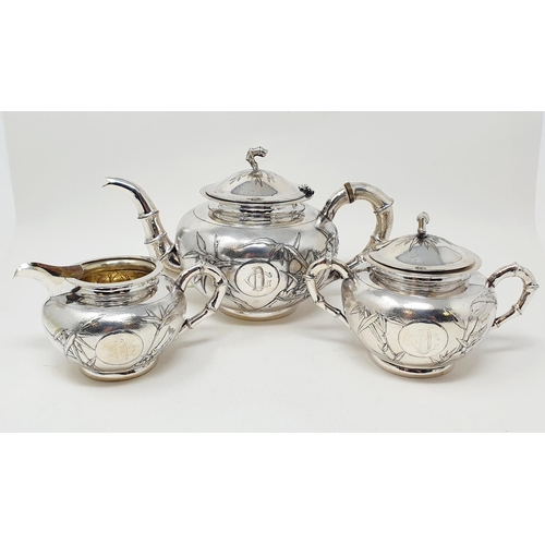 645 - A Chinese silver coloured metal three piece tea set, monogramed and decorated bamboo, comprising a t... 