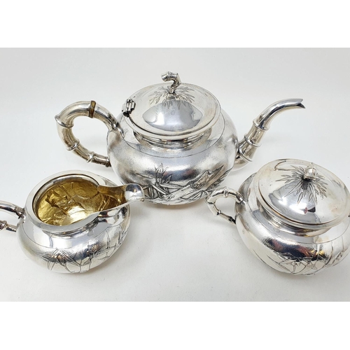 645 - A Chinese silver coloured metal three piece tea set, monogramed and decorated bamboo, comprising a t... 