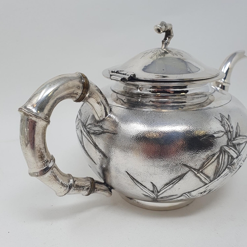 645 - A Chinese silver coloured metal three piece tea set, monogramed and decorated bamboo, comprising a t... 