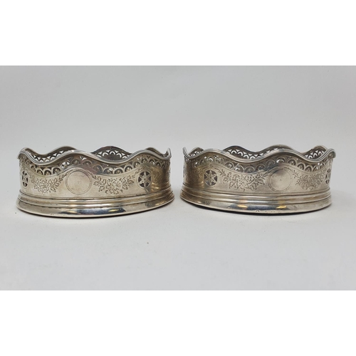 593 - A pair of early 19th century silver coasters, with a wavy rim, with pierced and engraved decoration,... 