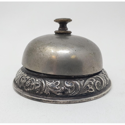 696 - A silver mounted table bell, with rococo style decoration, chester 1902, 8.5 cm diameter