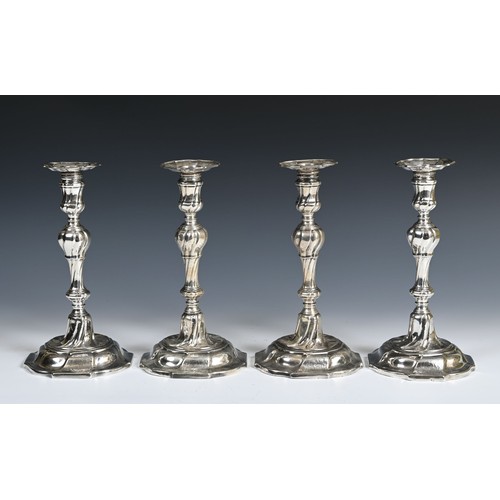 582 - An unusual set of four mid 18th century silver table candlesticks, engraved with an armorial, of wri... 