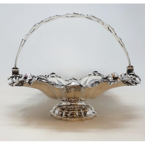 597 - A large William IV silver swing handle basket, engraved with an armorial and a motto, the handle and... 