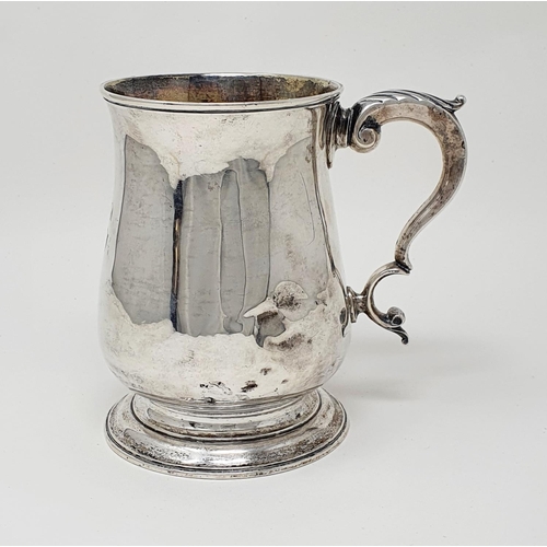 693 - A George III silver mug top of baluster form, with a leaf capped scroll handle, London 1770, 10.0 oz... 