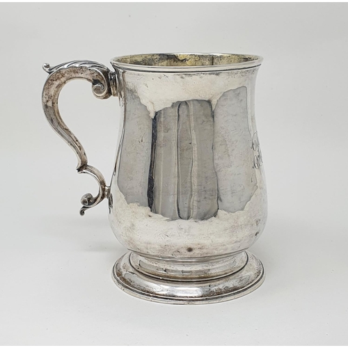 693 - A George III silver mug top of baluster form, with a leaf capped scroll handle, London 1770, 10.0 oz... 