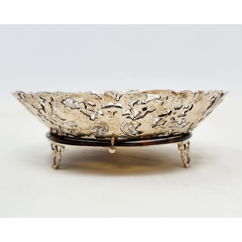 580 - A late Victorian silver and tortoiseshell dish, the borders pierced and decorated with cherubs, bird... 