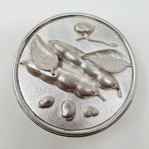 695 - A modern silver box and cover, of cylindrical form, the cover decorated peas in high relief, Asprey'... 