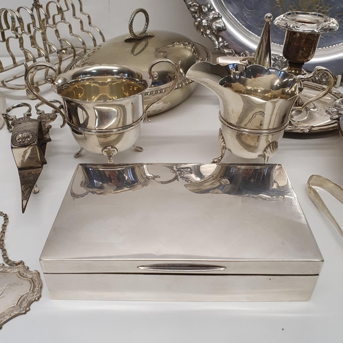 547 - A George V silver cigarette box, a silver cream jug, a matching sugar bowl, and assorted silver plat... 