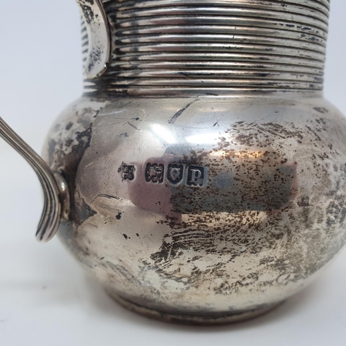 565 - A silver jug, with a reeded border, London 1910, 6.9 ozt, 8.5 cm high