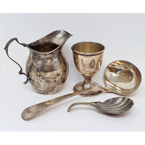 600 - A 19th century silver caddy spoon, crested, with a shell bowl, a silver ladle, a silver cream jug an... 