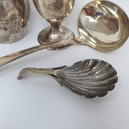 600 - A 19th century silver caddy spoon, crested, with a shell bowl, a silver ladle, a silver cream jug an... 