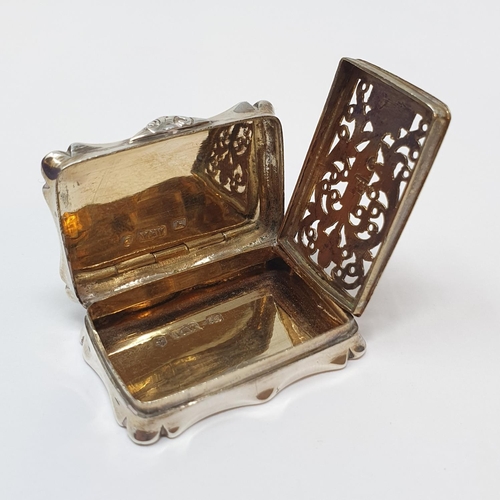 608 - An early Victorian silver vinaigrette, of shaped rectangular form, initialed and with engine turned ... 