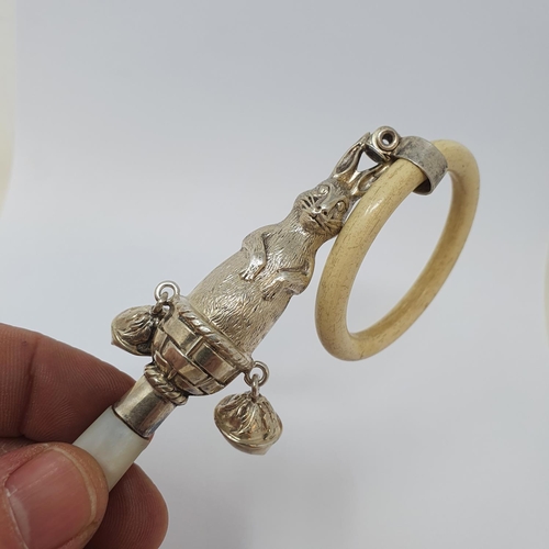 610 - An early 20th century silver coloured metal bone and mother of pearl baby's rattle, the stem in the ... 