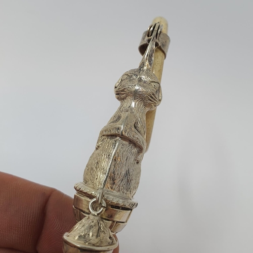 610 - An early 20th century silver coloured metal bone and mother of pearl baby's rattle, the stem in the ... 