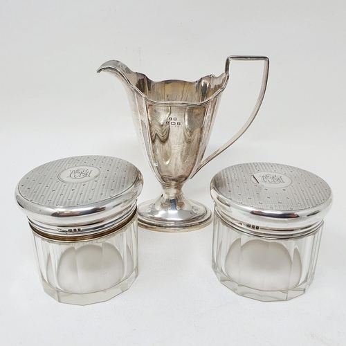 690 - A George III style cream jug, Birmingham 1906, 2.9 ozt, and two glass and silver mounted jars (3)