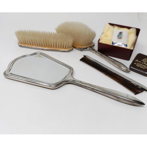 710 - A modern silver backed mirror, two matching brushes, and a comb (4)