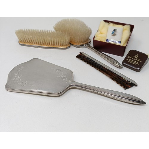 710 - A modern silver backed mirror, two matching brushes, and a comb (4)