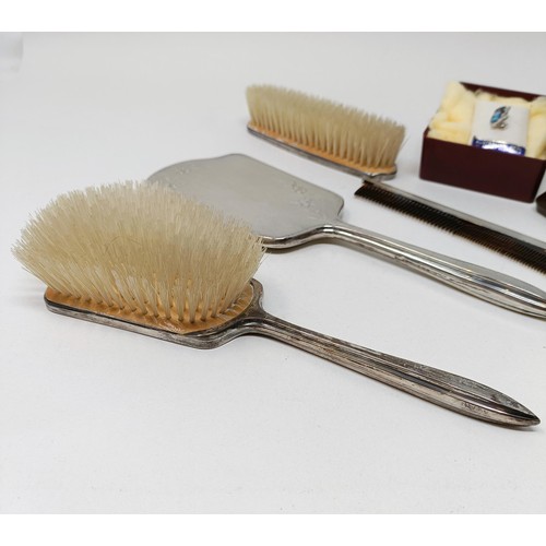 710 - A modern silver backed mirror, two matching brushes, and a comb (4)