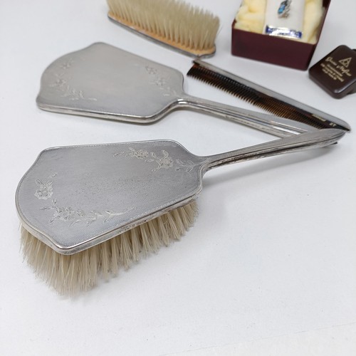 710 - A modern silver backed mirror, two matching brushes, and a comb (4)