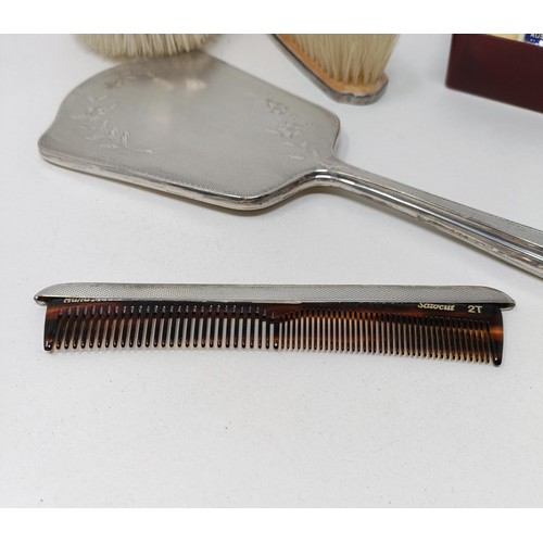 710 - A modern silver backed mirror, two matching brushes, and a comb (4)