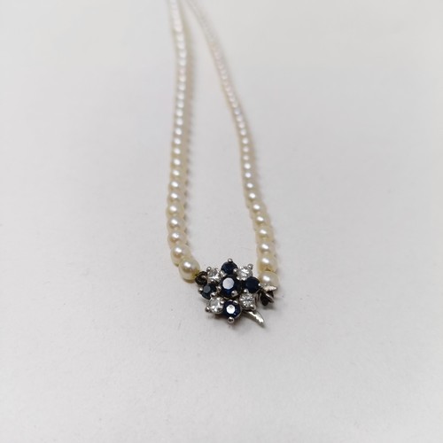 810 - A cultured pearl necklace, with a diamond and sapphire clasp