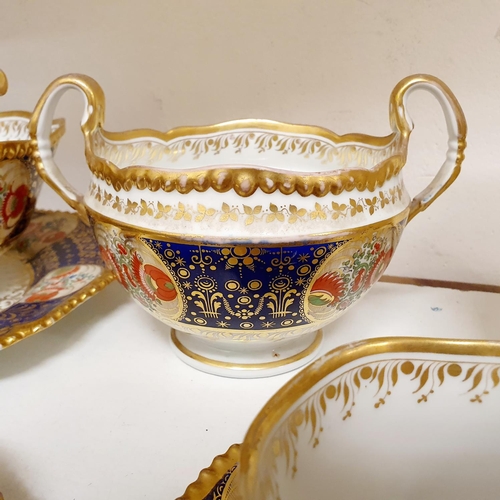 1006 - An early 19th century part tea service, having a blue border with roundels, decorated flowers highli... 