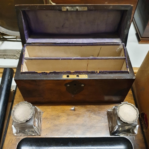 1039 - An early 20th century walnut desk stand, with glass inkwells with silver mounts, 30 cm wide, a domed... 