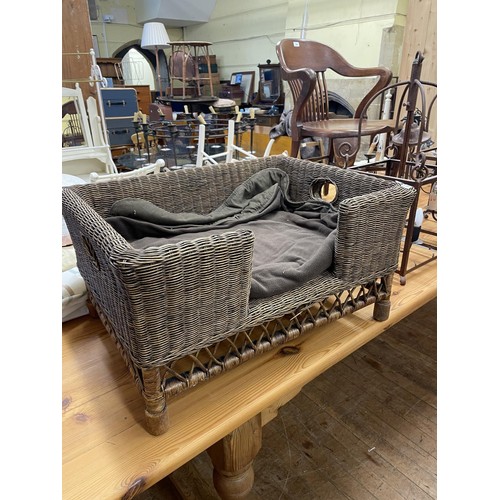 1283 - A wicker dog bed, four rolls of material, and a wicker log basket (6)