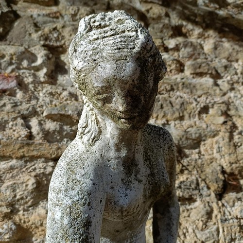 1310 - A composite stone garden statue of a lady, in a classical pose, 92 cm high