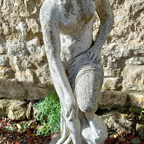 1310 - A composite stone garden statue of a lady, in a classical pose, 92 cm high