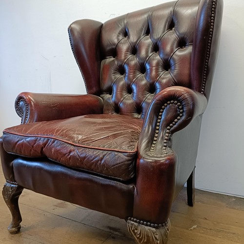 1326 - A red leather button backed wing armchair