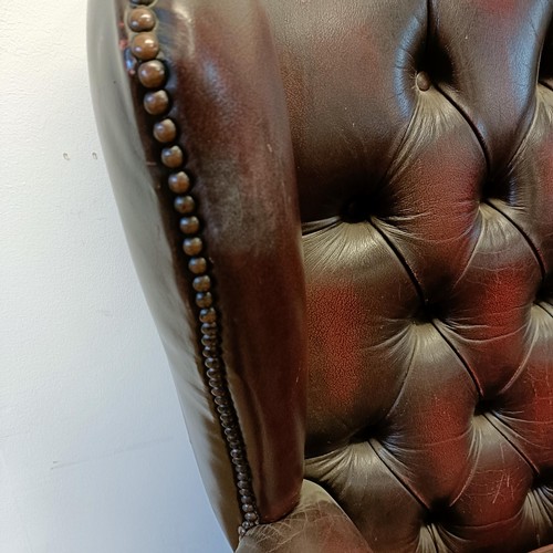 1326 - A red leather button backed wing armchair