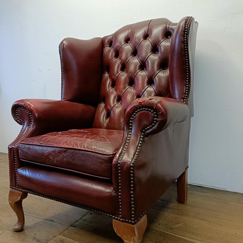 1327 - A red leather button backed wing armchair