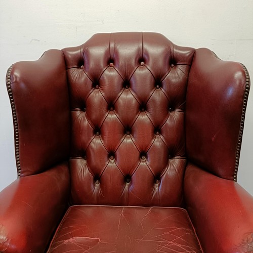 1327 - A red leather button backed wing armchair