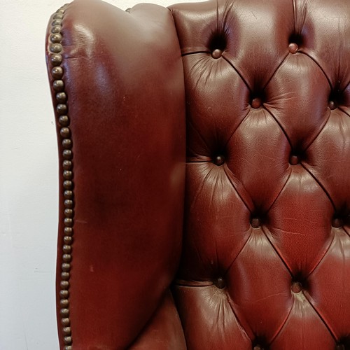 1327 - A red leather button backed wing armchair