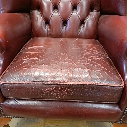 1327 - A red leather button backed wing armchair