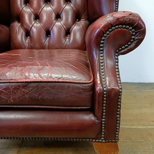 1327 - A red leather button backed wing armchair