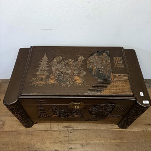 1319 - A carved camphorwood chest, decorated a landscape with figures, 100 cm wide