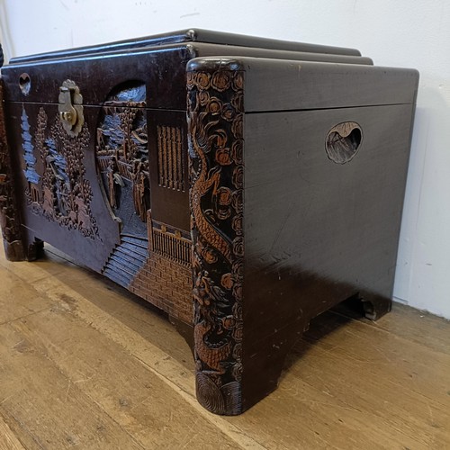 1319 - A carved camphorwood chest, decorated a landscape with figures, 100 cm wide