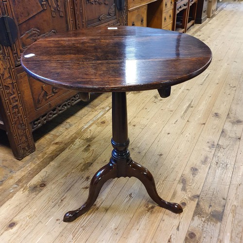 1201 - A 19th century oak tilt top table, on a column support to a tripod base, 54 cm diameter