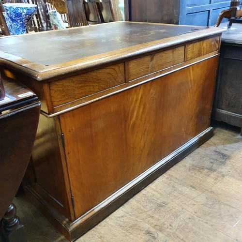 1202 - An oak pedestal desk, of nine drawer configuration, with cupboards to the sides, 122 cm wide